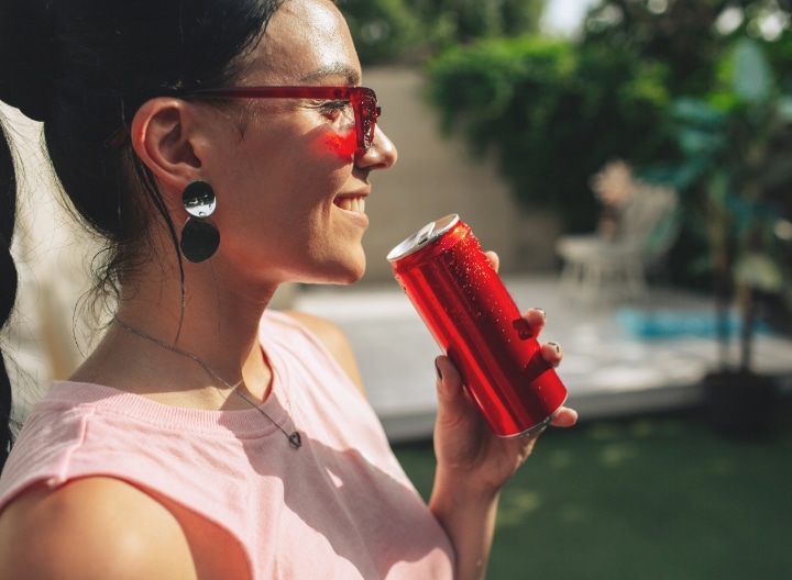 woman drinking canned beverage